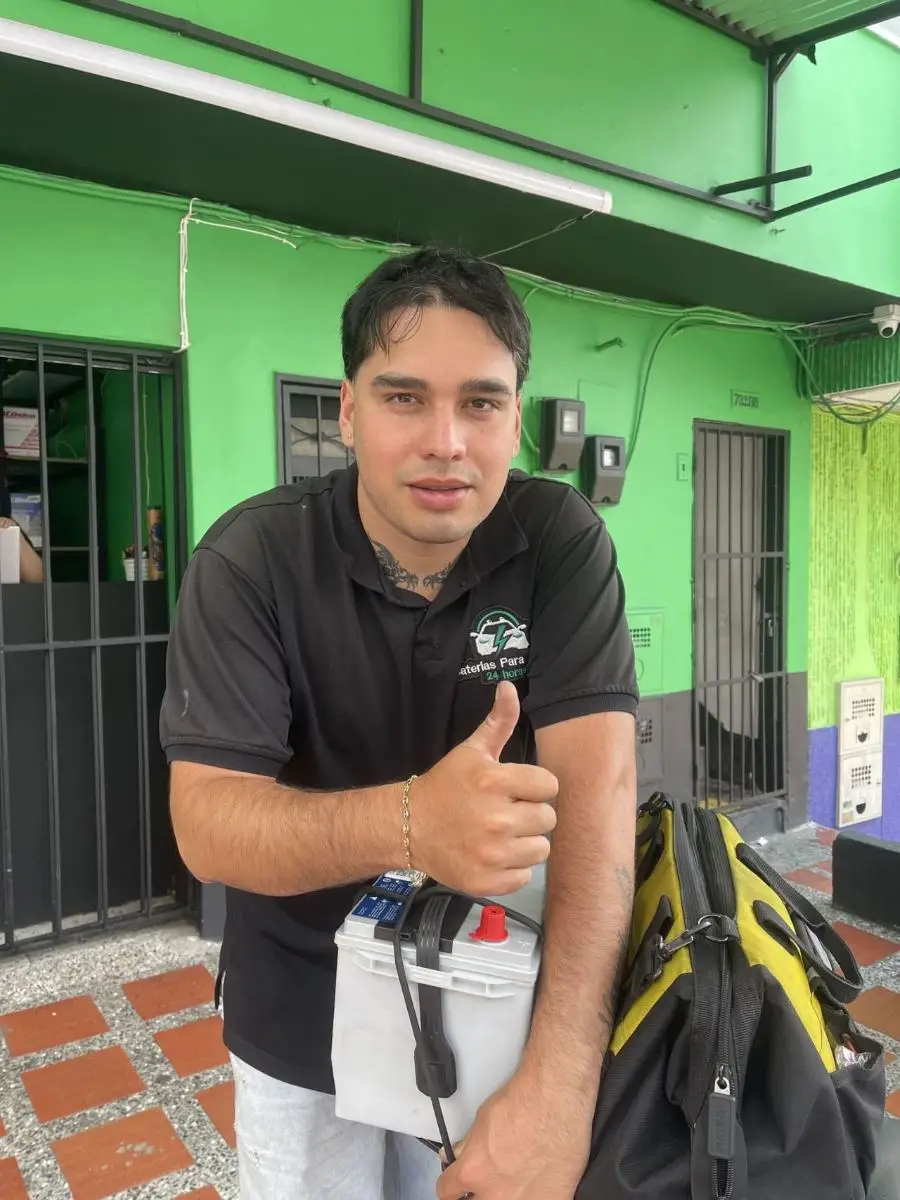 Técnico de Baterías Para Carro 24 Horas entregando una batería Varta